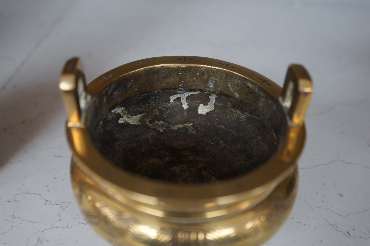 A Chinese engraved and chased bronze tripod censer, Xuande mark, early 20th century, 10.5cm. Condition - good